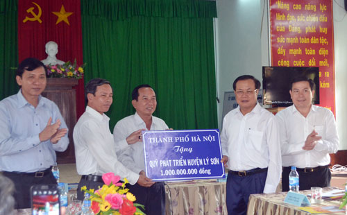 Ủy viên Bộ Chính trị, Bí thư Thành ủy Hà Nội Phạm Quang Nghị trao tặng số tiền do cán bộ và nhân dân Thủ đô đóng góp cho huyện đảo Lý Sơn.	Ảnh: Xuân Thiên